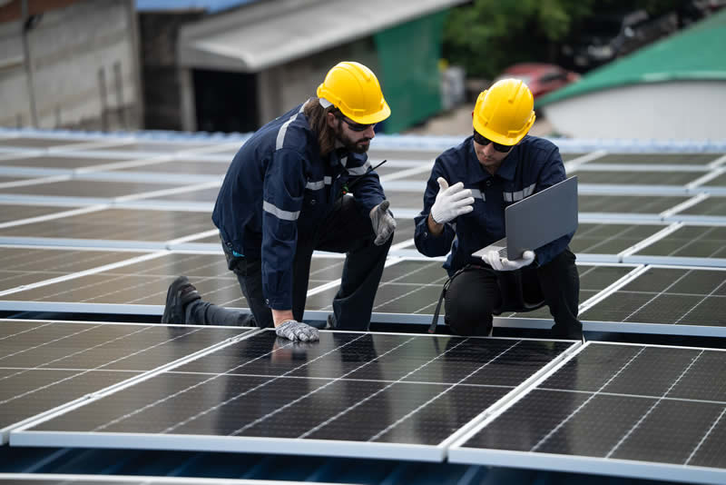 Two-technicians-working-on-solar-panels Two technicians working on solar panels.